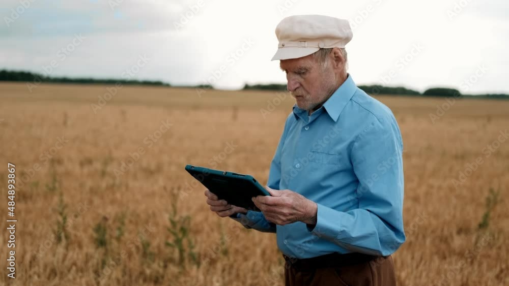 Old farmer using digital tablet. Old senior man farmer with digital tablet working in field smart farm. Smart farming. Farming technologies. Old farmer using digital tablet. Old senior man farmer with digital tablet working in field smart farm. Smart farming. Farming technologies.