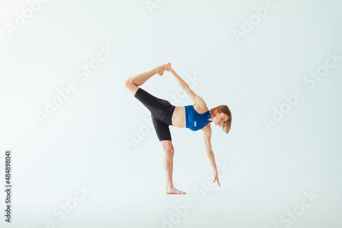 Beautiful sports woman in sportswear doing stretching on a white background.