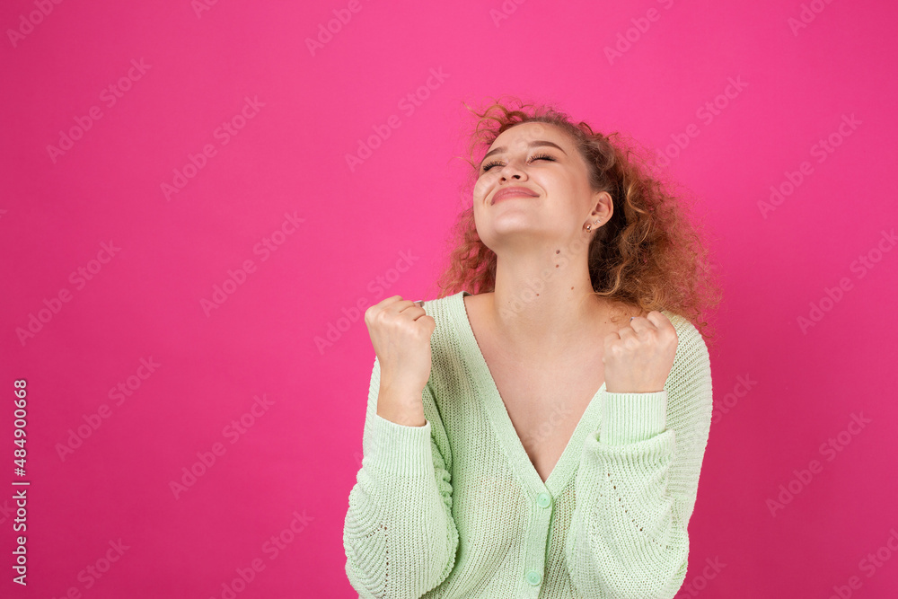 Happy young girl raises her fist up in delight! Successful victory gestures. Happy young girl raises her fist up in delight! Successful victory gestures.
