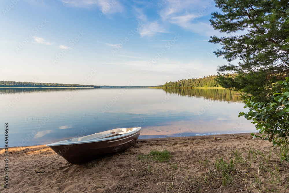 Lake with clear water at dawn and one boat on the shore Lake with clear water at dawn and one boat on the shore
