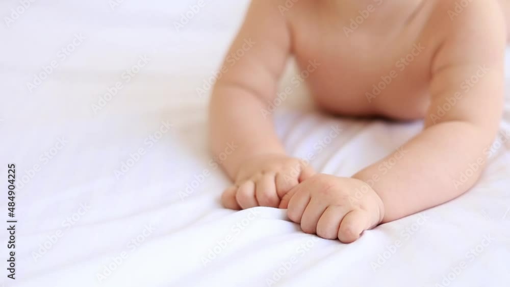 small hands and fingers of a newborn baby on a white cotton bed at home small hands and fingers of a newborn baby on a white cotton bed at home