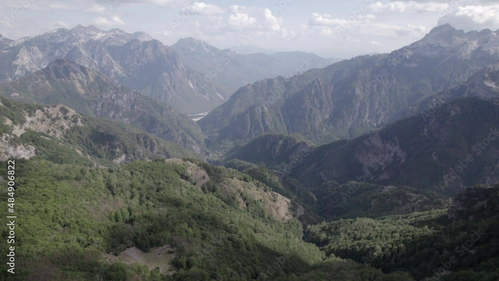 Frontal drone video, moving over the top of Theth Valley and Valbona Valley in the background. Clear sky with clouds. Frontal drone video, moving over the top of Theth Valley and Valbona Valley in the background. Clear sky with clouds.