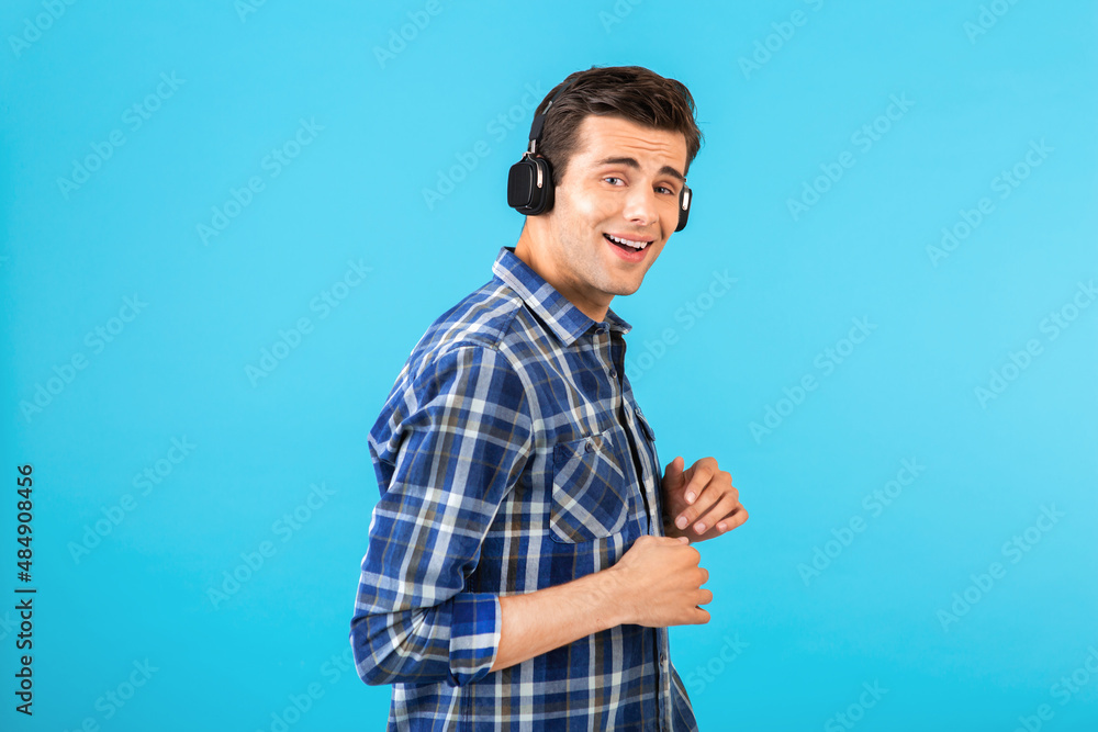 Fototapeta premium stylish young man listening to music on wireless headphones