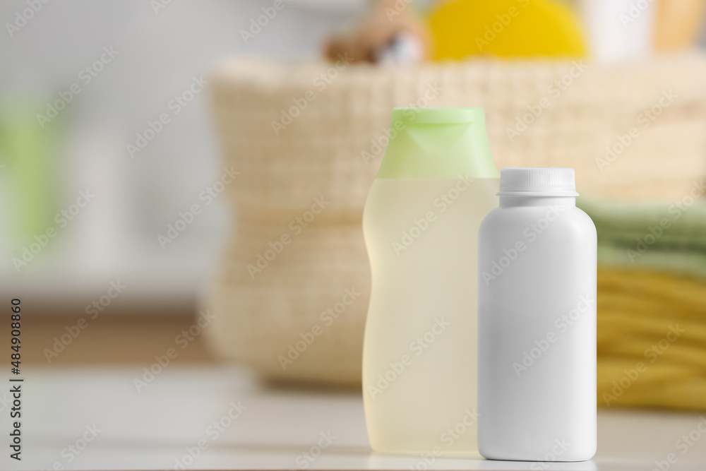 Bottles of baby cosmetic products and towels on white table, space for text Bottles of baby cosmetic products and towels on white table, space for text