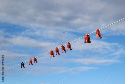  clothesline with red plastic clothespins against blue sky