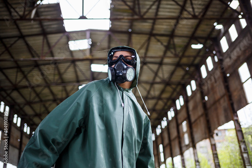 Fotografie A man in a protective mask and protective clothing explores the danger zone