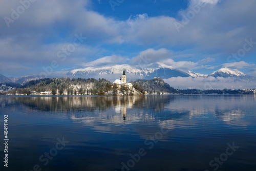 Scenic view of lake Bled and the church on an island in winter with mountains behind in clouds in Slovenia © kato08