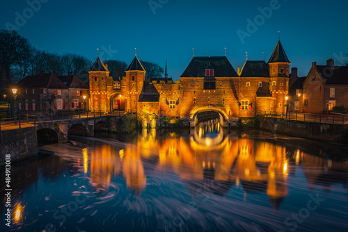 An old medieval gate called the Koppelpoort in Amersfoort with a beautiful reflection in the water during the blue hour