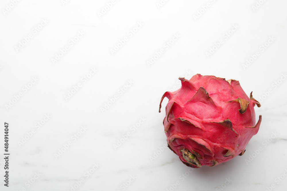 Delicious red pitahaya fruit on white marble table, top view. Space for text Delicious red pitahaya fruit on white marble table, top view. Space for text
