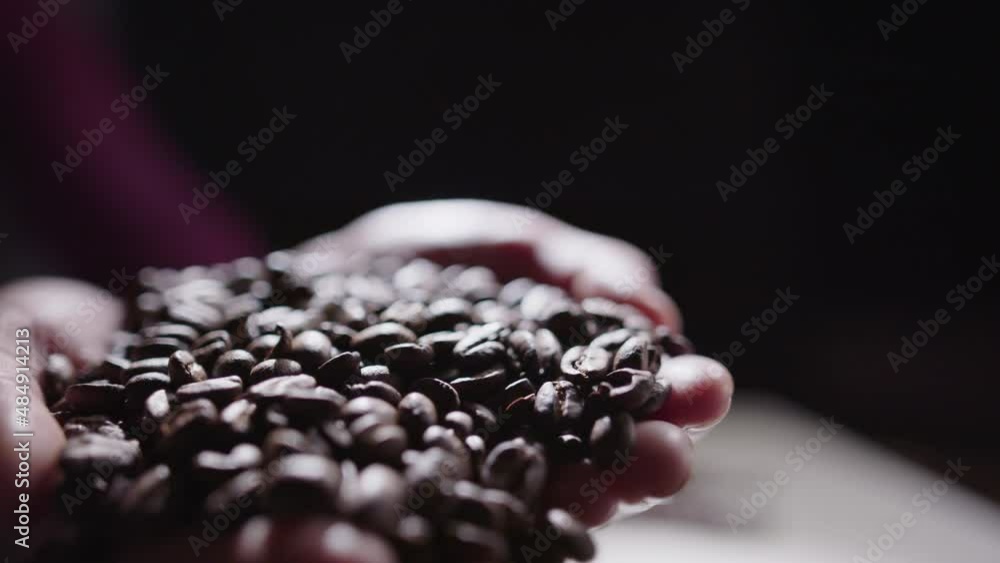 SHALLOW FOCUS SLOW MOTION - hands full of coffee beans SHALLOW FOCUS SLOW MOTION - hands full of coffee beans