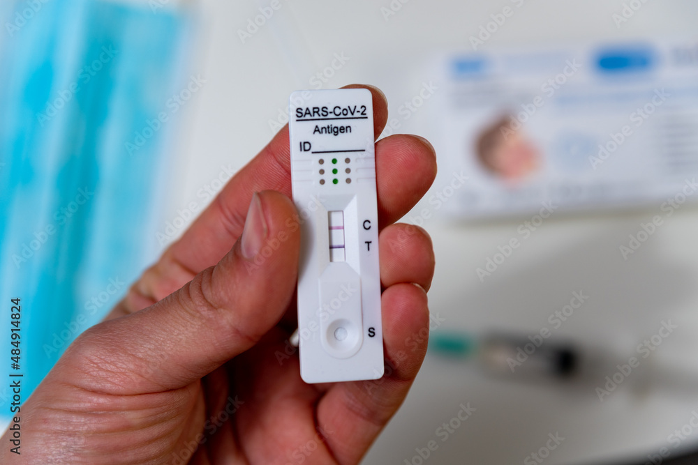 A hand is seen holding a rapid Covid test, also known as antigen test