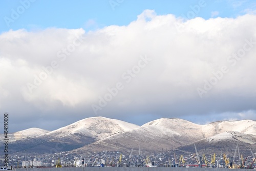 Snowy mountain peaks at the foot of a port city on the Black Sea coast.