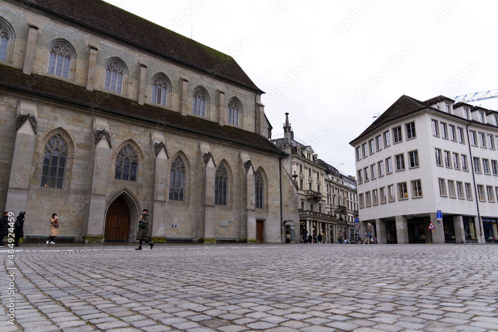 Protestant church Women's minster with paving stones at Minster Square in the old town of Zürich at a gray and cloudy winter day. Photo taken February 1st, 2022, Zurich, Switzerland.