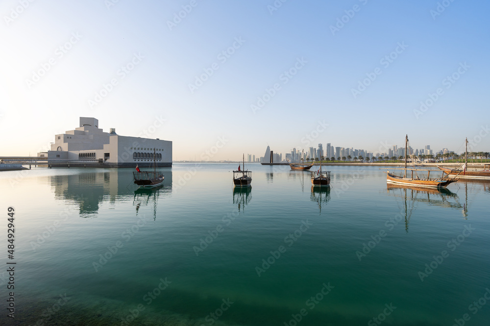 DOHA, QATAR - JANUARY 25, 2022: Museum of Islamic Arts with traditional wooden dhows in foreground. DOHA, QATAR - JANUARY 25, 2022: Museum of Islamic Arts with traditional wooden dhows in foreground.