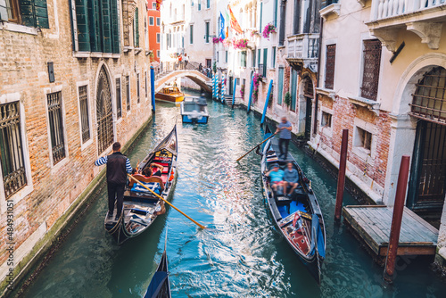 Venetian gondoliers carries tourists on gondola Grand Canal of Venice in romantic Italy, boat transportation and sightseeing excursion during daytime for exploring Venezian historic landscape © BullRun