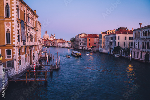 Romantic city in Europe with motorboats floating on Grand Canal during evening time for exploring Venice  Italian architecture and picturesque historic center with ancient landscape for discovering