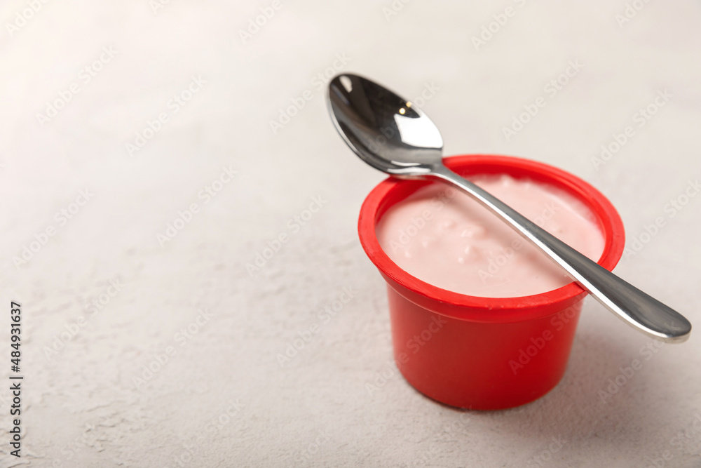 strawberry yogurt in a red plastic cup with a spoon on a white background.
Copy space. strawberry yogurt in a red plastic cup with a spoon on a white background.
Copy space.