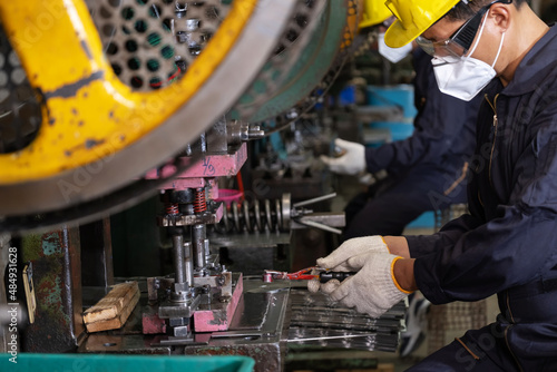 Engineer man wearing safety glass and hygiene mask working in the CNC metal factory. Selective focus on hand. New normal working at the plant. Come back to work after COVID 19