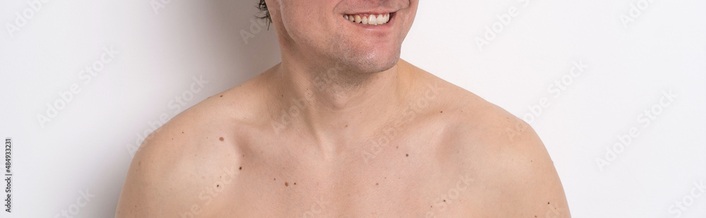 Naklejka premium Men beauty skin care ads concept. Man with smile and bare shoulders looking sideways of camera isolated on white background. Male cosmetology concept. Age spots and male skin care concept. 