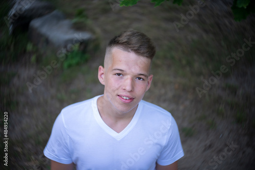 Portrait of a teenager on the background of nature. View from above. Natural skin of the face, without retouching.
