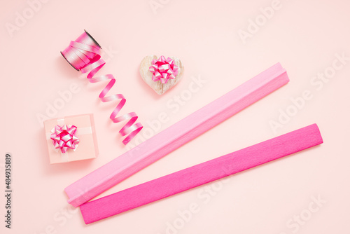 Gift box, ribbons and heart on pastel pink background. Valentine's Day or Love concept.  Flat lay.