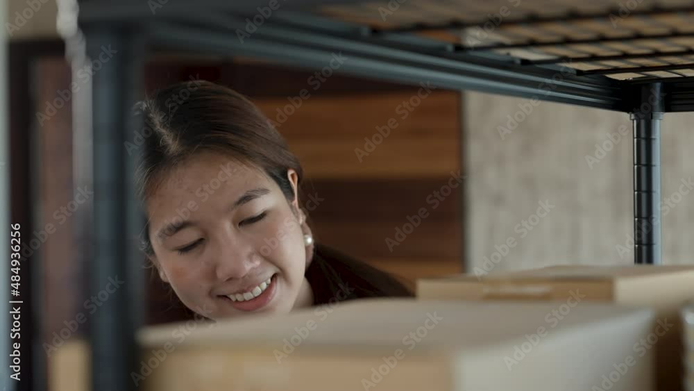 4K, A beautiful online seller in Asia checks parcel boxes and prepares to deliver to customers with happy smiling faces.