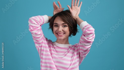 Lady make hands shot grimace tongue out ears isolated blue color background