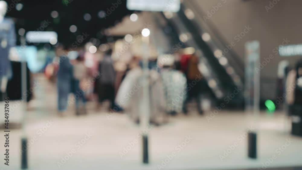 Blurred shopping mall inside with many blurred people walking in protective medical face mask. Shopping centre background Blurred shopping mall inside with many blurred people walking in protective medical face mask. Shopping centre background