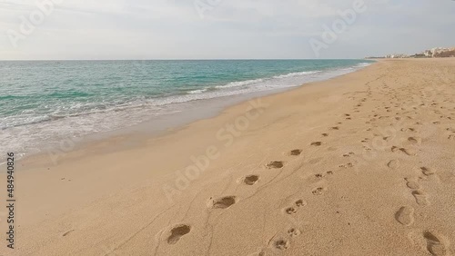beautiful mediterranean beach sand footprints turquoise blue calm water photo