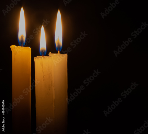 candle on a dark background. three candles. candle flame close-up.