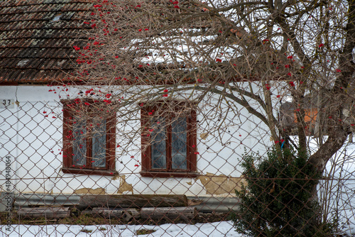 Destroyed and ruined house with red ceramic tiles, abandoned in the village