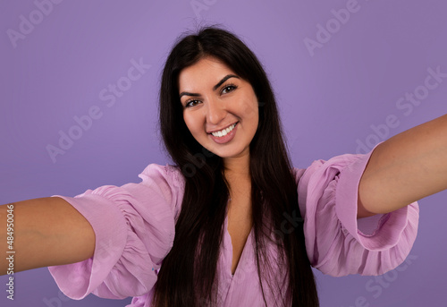 Photography concept. Portrait of positive armenian woman taking selfie picture, making front selfportrait