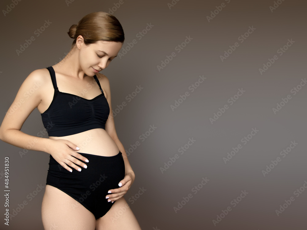 pregnancy, rest, people and expectation concept - happy pregnant woman touching her belly at white studio pregnancy, rest, people and expectation concept - happy pregnant woman touching her belly at white studio