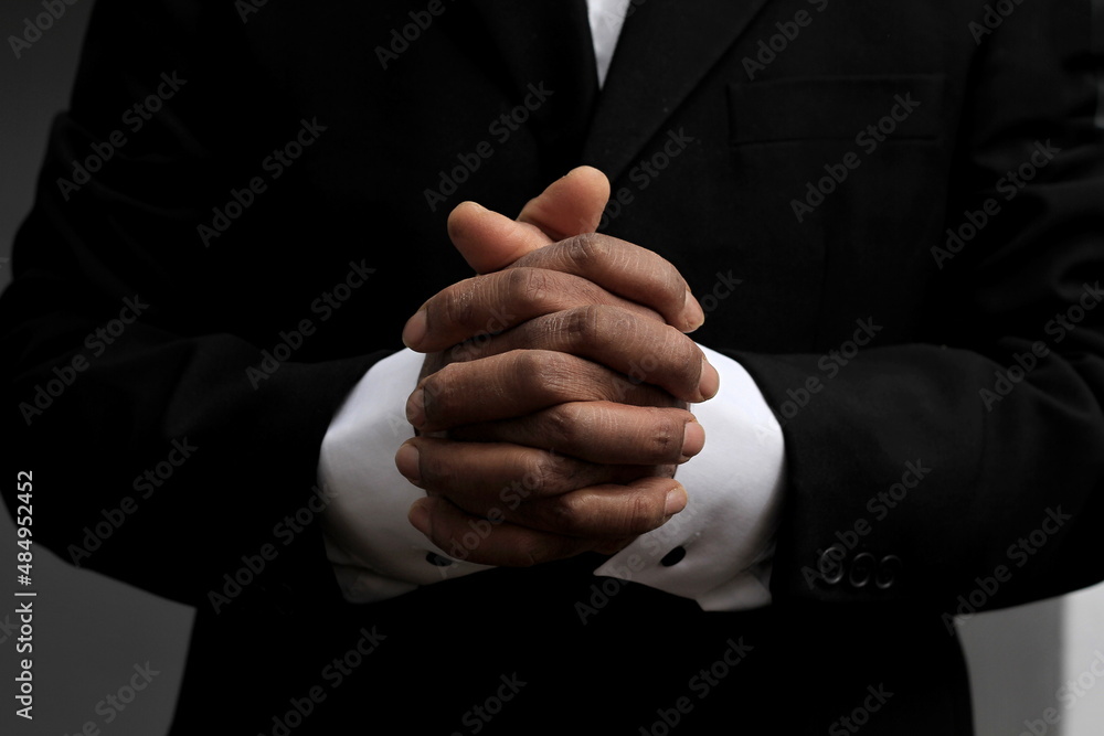 man praying to god with hands together stock photo	