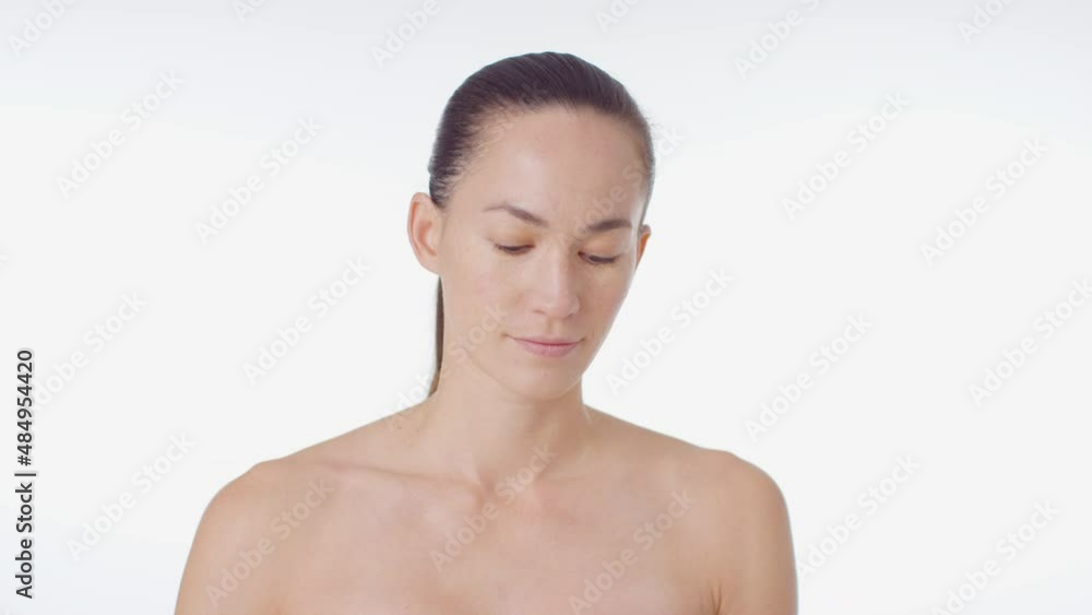 Mid Shot of Young Woman Smiling and Applying Concealer Mid Shot of Young Woman Smiling and Applying Concealer