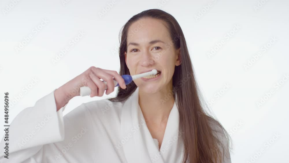 Mid Shot of Young Woman Smiling and Brushing her Teeth Mid Shot of Young Woman Smiling and Brushing her Teeth