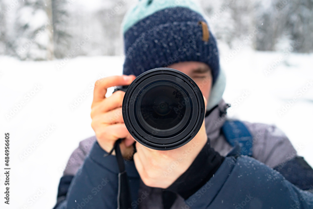 A man takes pictures on the street with an analog camera, a close-up lens, a photographer. The guy photographs the winter landscape