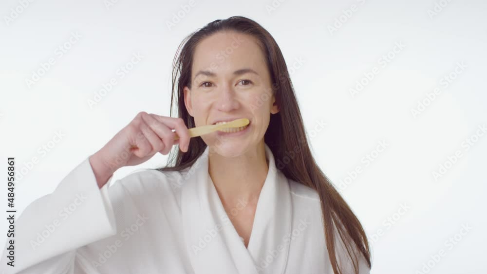 Mid Shot of Young Woman Smiling and Brushing Her Teeth Mid Shot of Young Woman Smiling and Brushing Her Teeth