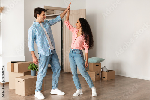 Happy man and woman giving high five celebrating moving day