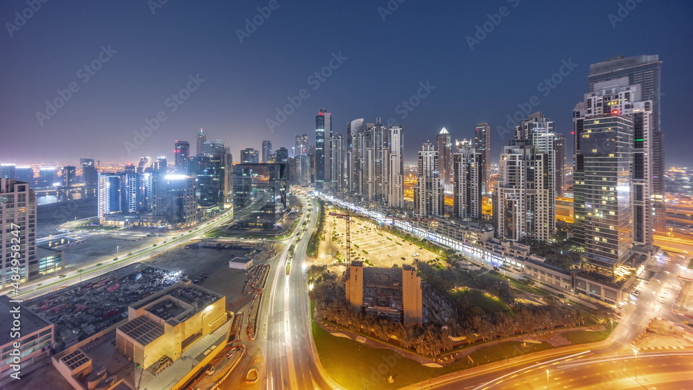 Bay Avenue with modern towers residential development in Business Bay aerial panoramic night to day timelapse, Dubai