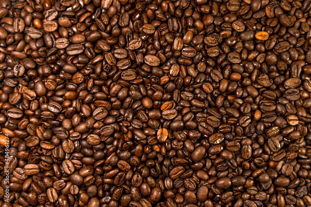 Coffee beans background. Top view of roasted coffee beans spread out on the surface. Coffee beans background. Top view of roasted coffee beans spread out on the surface.