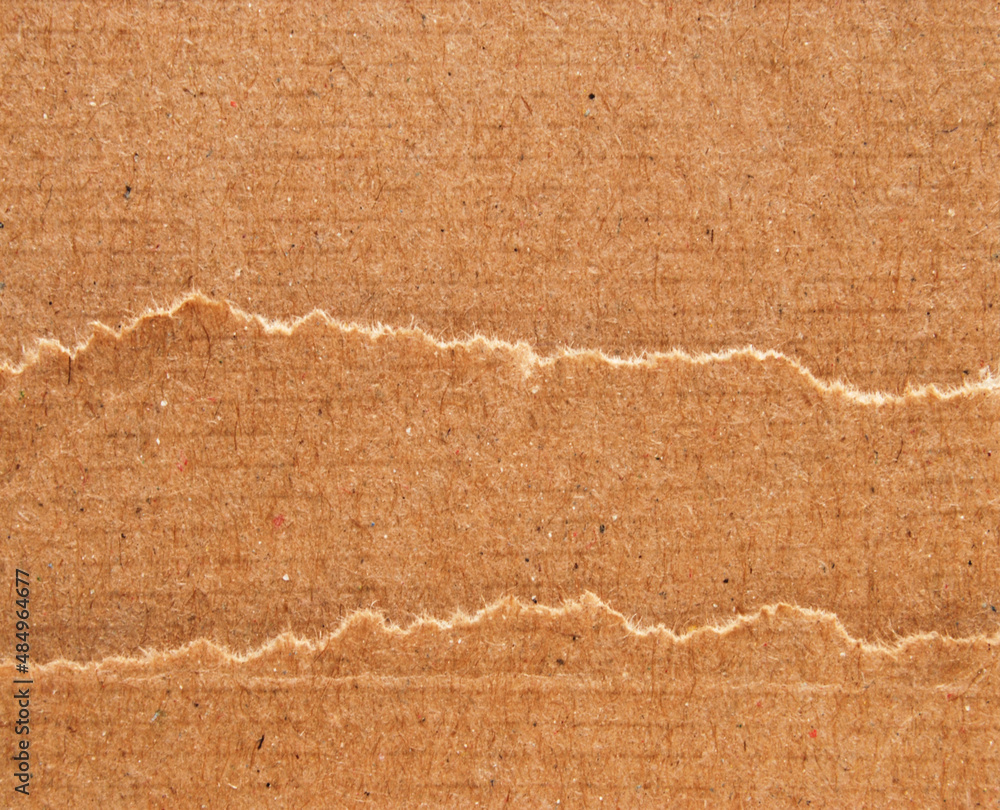 Some sheets of brown recycled cardboard with ripped edges stacked on top of each other for background Some sheets of brown recycled cardboard with ripped edges stacked on top of each other for background