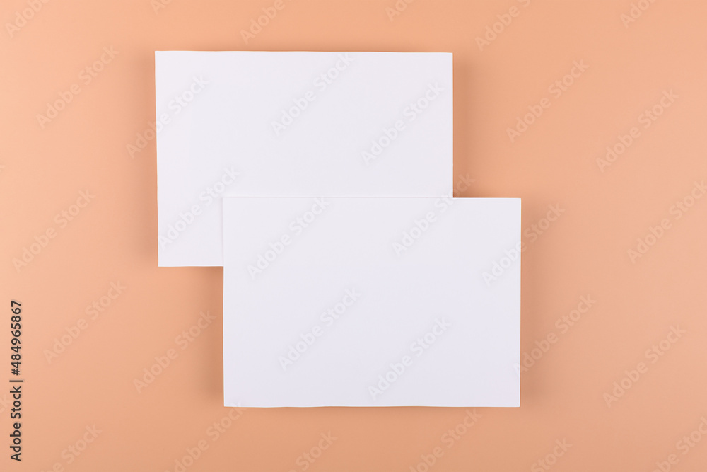 Card mockup of two empty white 5x7 card invitations on beige or terracotta nude background. Minimal simple functional background design with neutral colors Card mockup of two empty white 5x7 card invitations on beige or terracotta nude background. Minimal simple functional background design with neutral colors