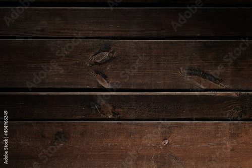 Wooden horizontal brown planks background. Brown wooden boards close-up. Texture of painted brown fence boards. Timber fence, desk surface.