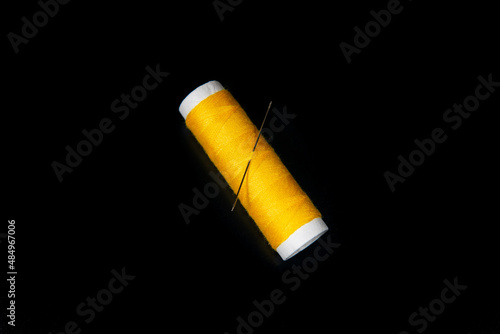 yellow sewing thread on black background for designers