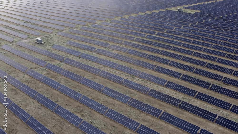 Aerial view of a large solar power plant in the desert. A huge solar station on a dry field. Endless rows of solar panels. Aerial view of a large solar power plant in the desert. A huge solar station on a dry field. Endless rows of solar panels.
