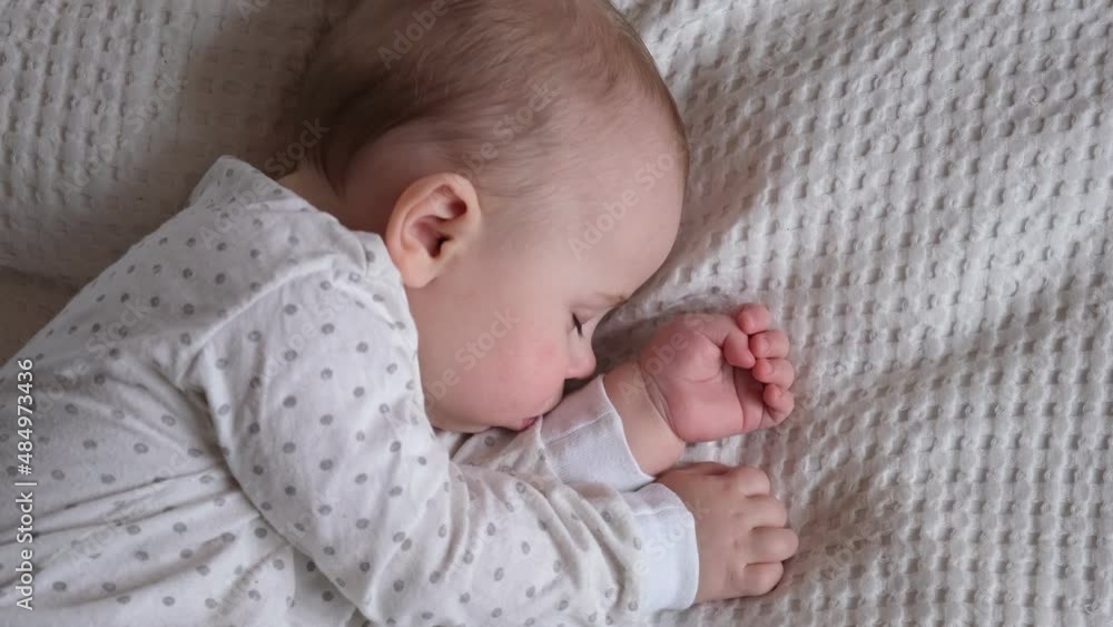 Peaceful adorable baby sleeping on his bed in a room at home. Sleeping newborn baby concept. 6 month-old baby girl sleeps at home. A serene dream. Face Close Up. Peaceful adorable baby sleeping on his bed in a room at home. Sleeping newborn baby concept. 6 month-old baby girl sleeps at home. A serene dream. Face Close Up.