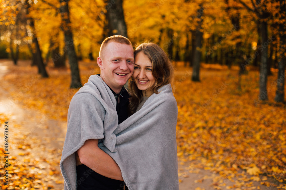 Young couple is walking in the sunny autumn park. Happy boy and girl are rolling themselves in the rug near yellow tree. Fallen yellow leaves, brith warm autumn weather. Autumn love story in park
Young couple is walking in the sunny autumn park. Happy boy and girl are rolling themselves in the rug near yellow tree. Fallen yellow leaves, brith warm autumn weather. Autumn love story in park