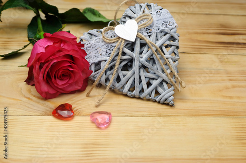 Valentine's day horizontal composition with wicker heart, glass hearts and rose, can be used for greeting cards, posters, placards, covers, etc.