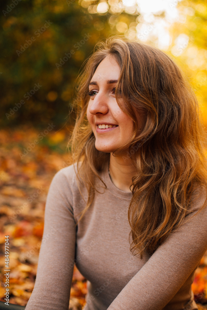 Beautiful girl is sitting on yellow leaves in the park. Attractive woman wearing beige sweater and black pants is walking in autumn park. Bright, warm sunny autumn day with yellow background.
Beautiful girl is sitting on yellow leaves in the park. Attractive woman wearing beige sweater and black pants is walking in autumn park. Bright, warm sunny autumn day with yellow background.
